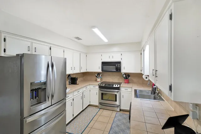 a kitchen with stainless steel appliances a refrigerator stove and sink