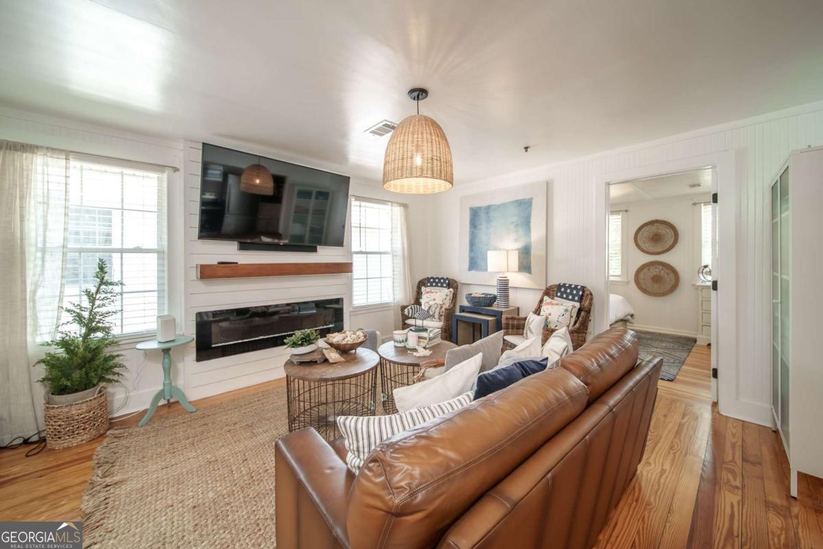 1413 2nd Avenue, Unit 2 Tybee Island, GA 31328 - Photo 11 of 30 a living room with furniture a fireplace and a flat screen tv