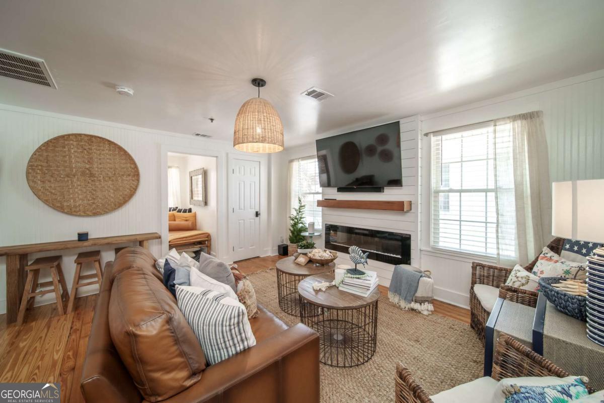 1413 2nd Avenue, Unit 2 Tybee Island, GA 31328 - Photo 12 of 30 a living room with furniture a flat screen tv and a large window