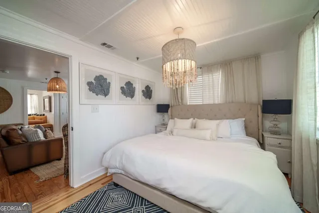 a bedroom with a large bed and a chandelier