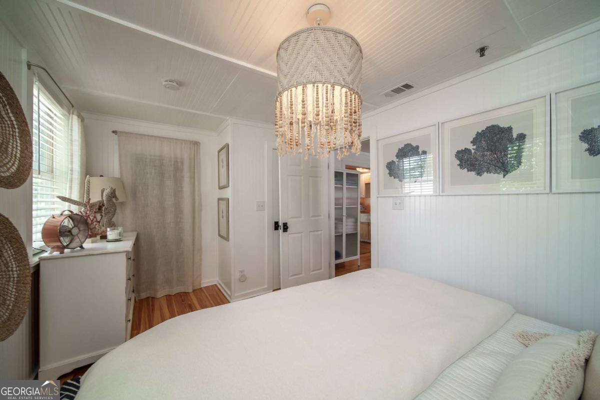 1413 2nd Avenue, Unit 2 Tybee Island, GA 31328 - Photo 17 of 30 a bedroom with a bed and a chandelier