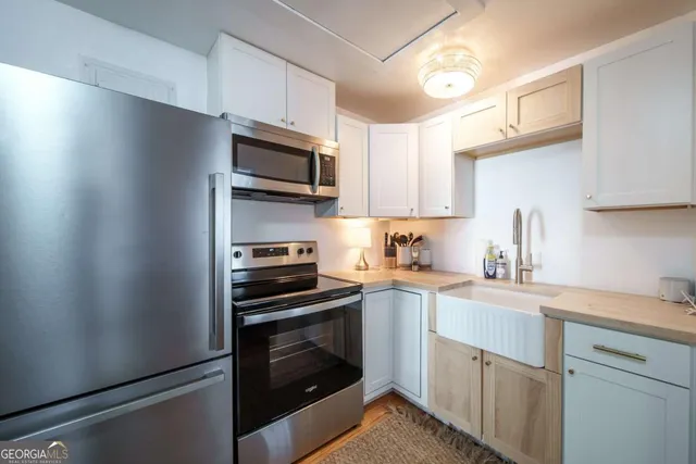 a kitchen with cabinets stainless steel appliances and a sink