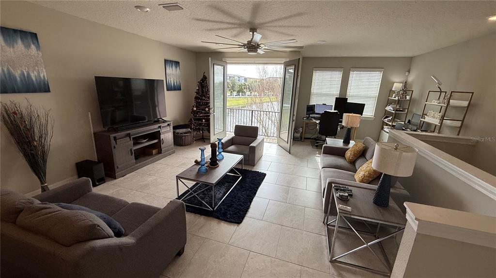 7718 Sweet Star Avenue Orlando, FL 32836 - Photo 21 of 51 a living room with furniture a flat screen tv and a large window