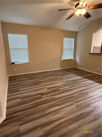 a view of a room with wooden floor and ceiling fan