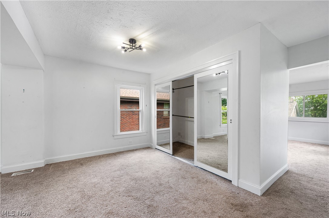 371 Merriman Road Akron, OH 44303 - Photo 14 of 27 Carpeted interior space featuring white walls, a modern ceiling light fixture, and a window with white trim