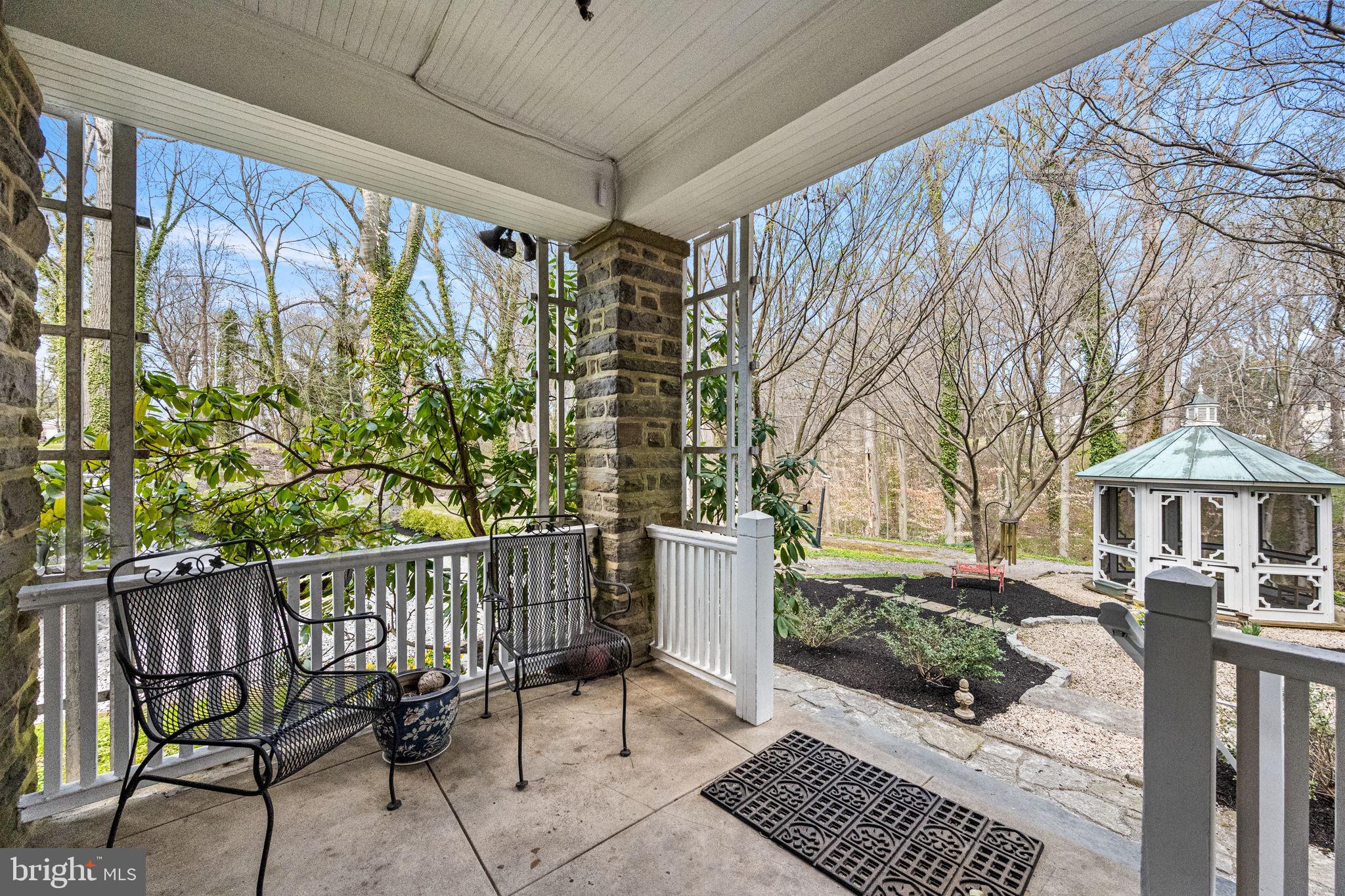 1018 Beech Road Wallingford, PA 19086 - Photo 49 of 66 a porch with a bench next to a yard