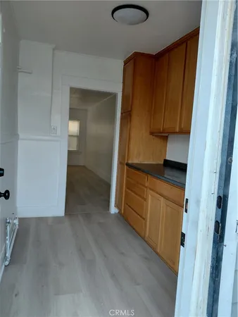 a view of a kitchen with wooden floor and cabinets