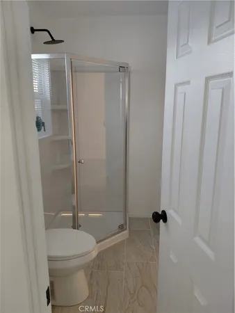 a bathroom with a granite countertop toilet and a shower