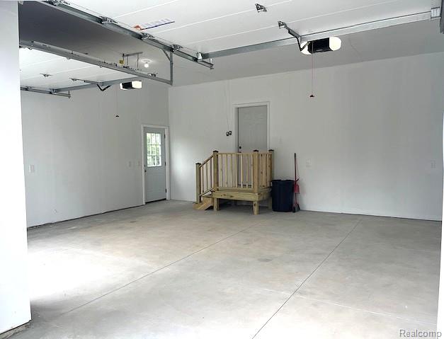 2670 Riley Center Road Memphis, MI 48041 - Photo 23 of 24 Spacious garage featuring a concrete floor, white walls, and dual garage door openers