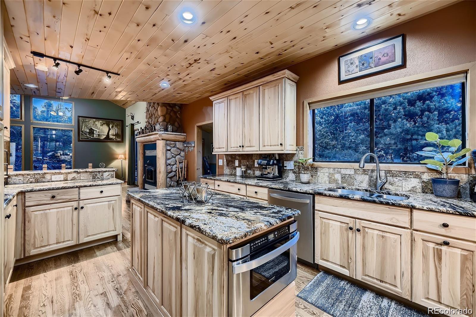37 Juniper Court Evergreen, CO 80439 - Photo 10 of 44 a kitchen with stainless steel appliances granite countertop a stove sink and cabinets
