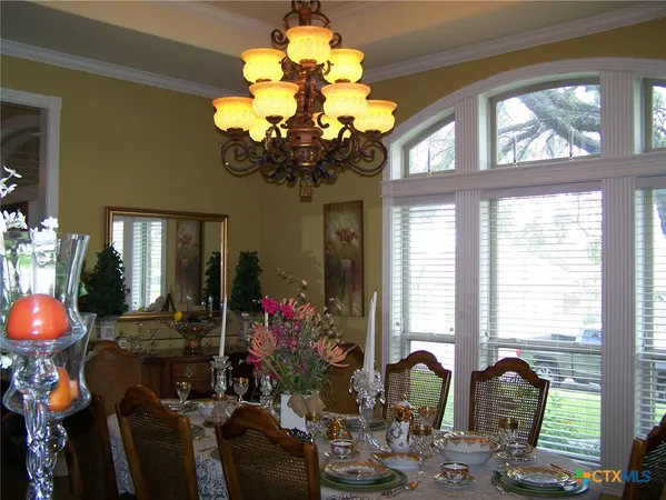a front view of a dining room filled with furniture and chandelier
