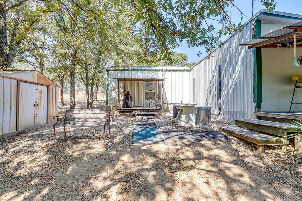 436 Luke Road Springtown, TX 76082 - Photo 26 of 39 Back of property featuring a storage unit and a metal roof