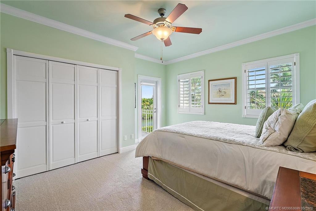 4105 Rigels Cove Way Jensen Beach, FL 34957 - Photo 47 of 80 a bedroom with a bed and a chandelier