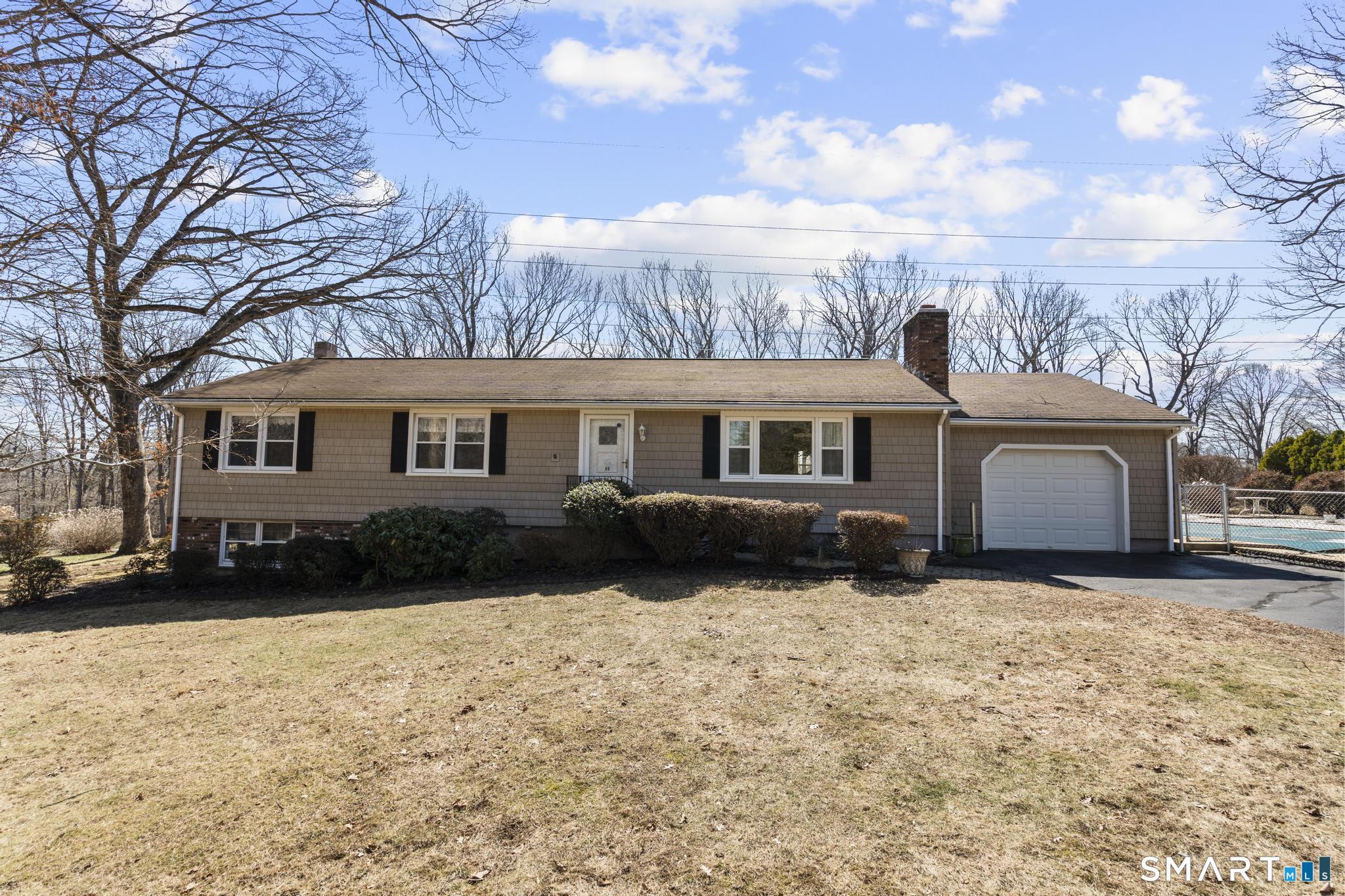a front view of a house with a yard covered in snow