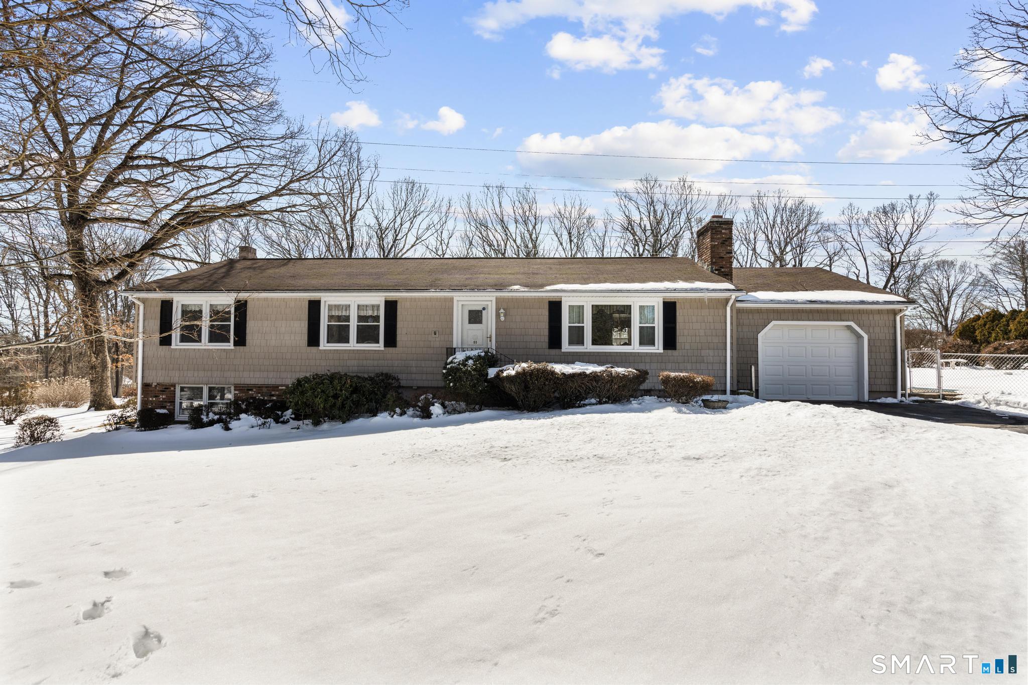 a front view of a house with a yard covered in snow