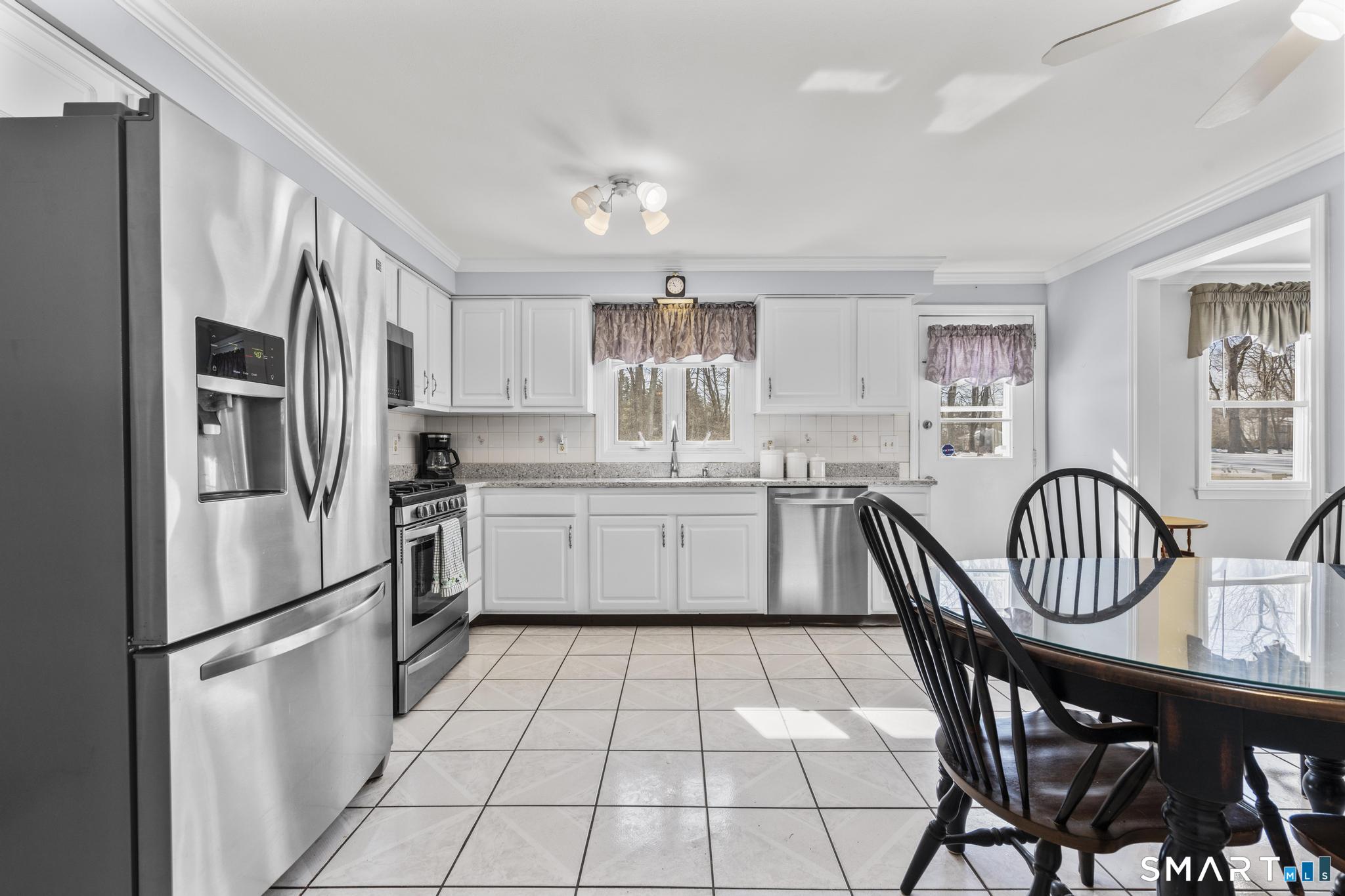 60 Quail Trail Trumbull, CT 06611 - Photo 20 of 37 a kitchen with stainless steel appliances granite countertop a refrigerator a sink a stove a dining table and chairs
