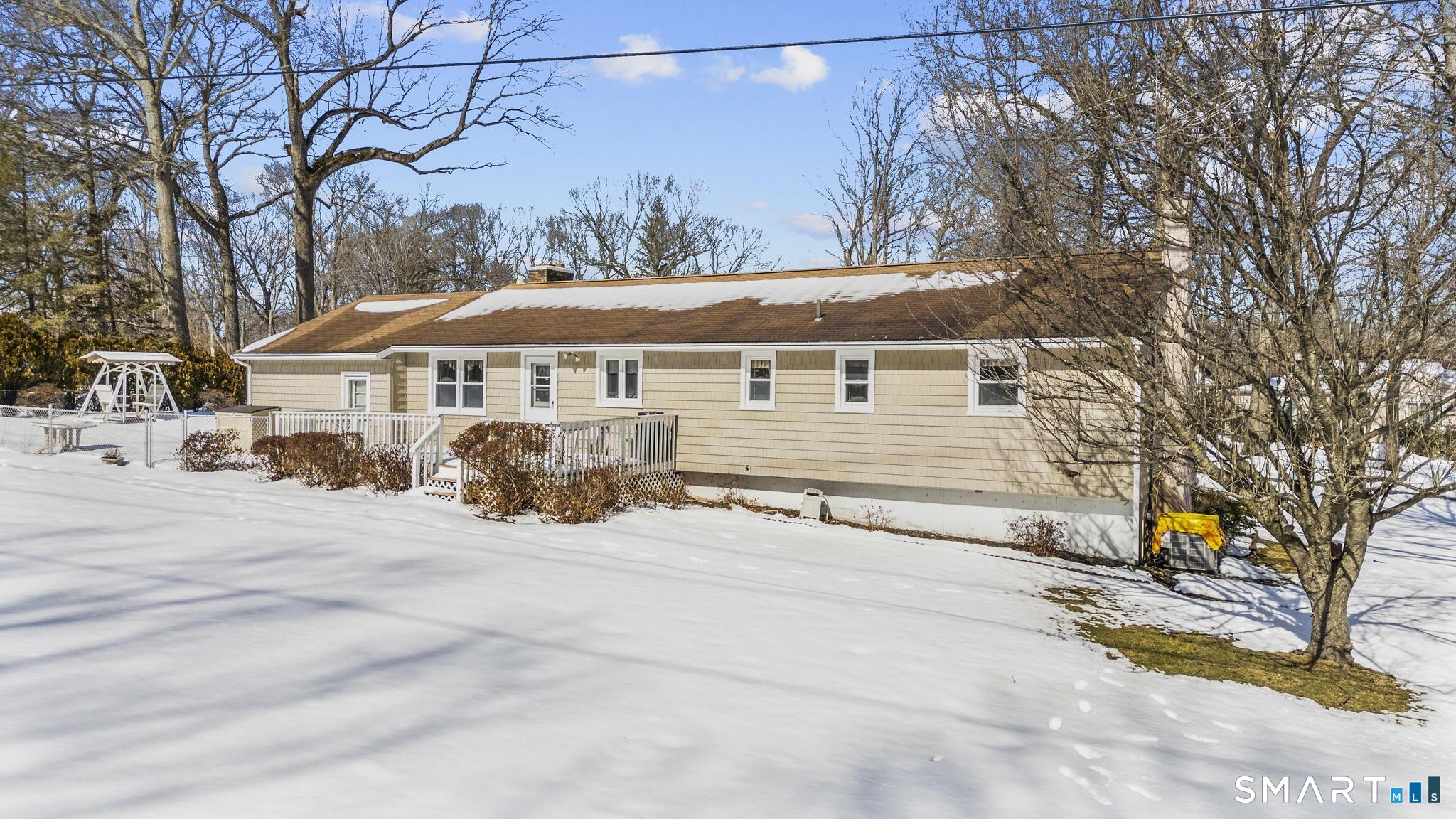 60 Quail Trail Trumbull, CT 06611 - Photo 3 of 37 a view of a white house with a large tree and wooden fence