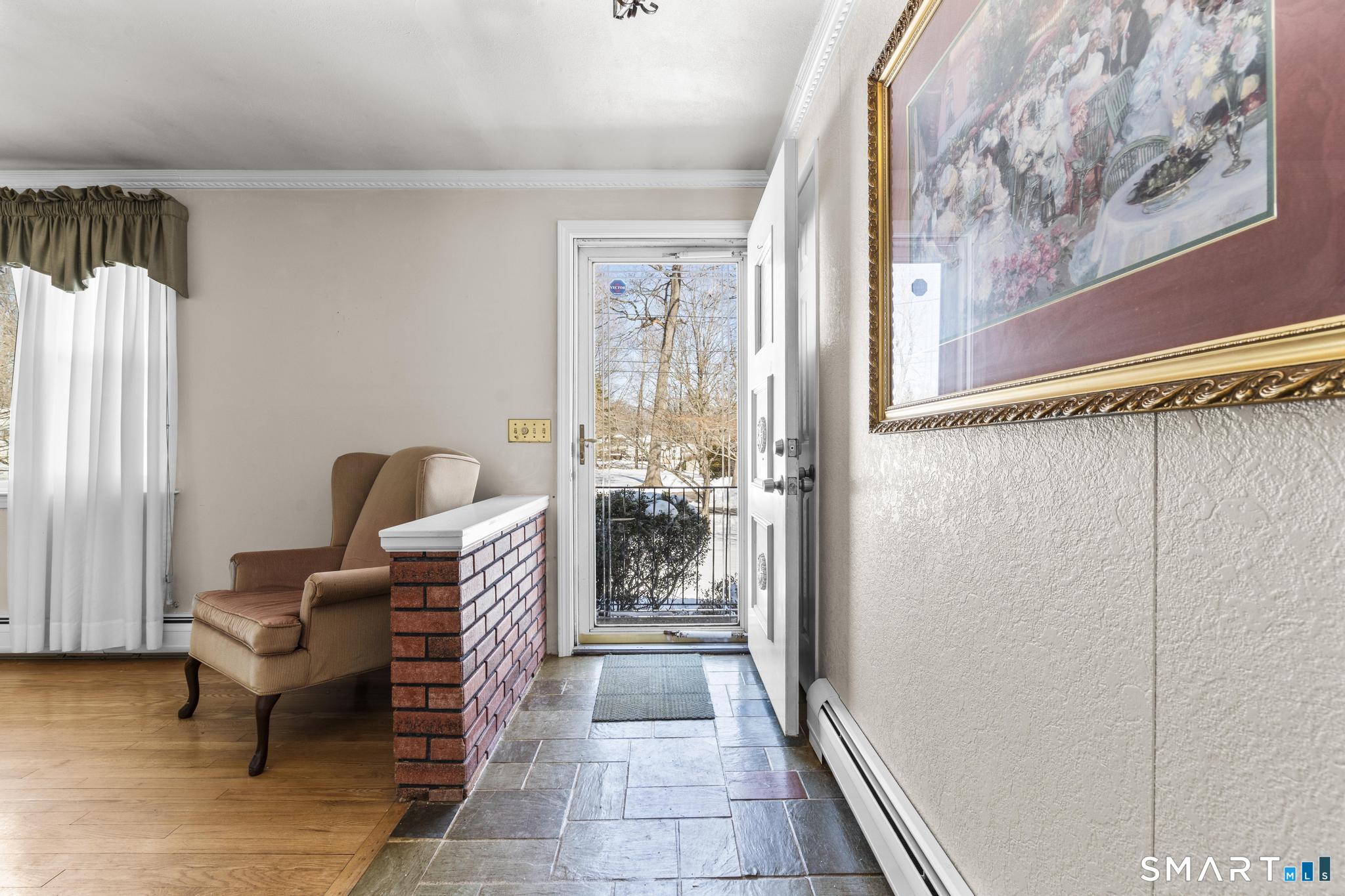 60 Quail Trail Trumbull, CT 06611 - Photo 33 of 37 a hallway with a couch and a dining table with wooden floor