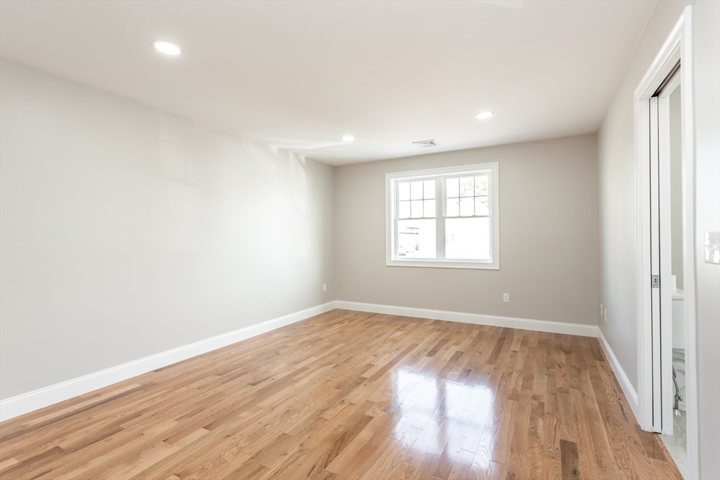 579 Summit Street, Unit 3 Fall River, MA 02724 - Photo 15 of 34 an empty room with wooden floor and windows
