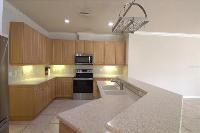 a kitchen with stainless steel appliances granite countertop a sink a stove and a refrigerator