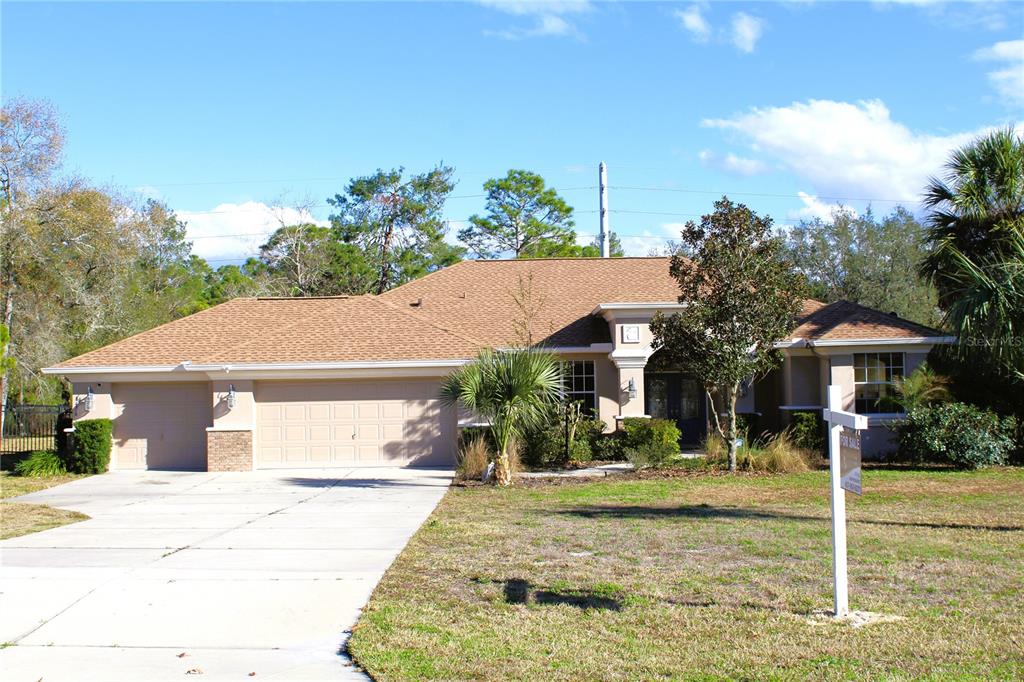 8476 Madrid Road Weeki Wachee, FL 34613 - Photo 19 of 59 a front view of a house with garden