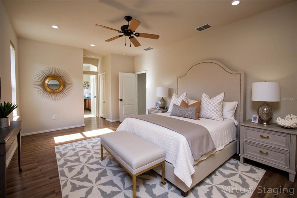 8476 Madrid Road Weeki Wachee, FL 34613 - Photo 7 of 59 a spacious bedroom with a bed a dresser and wooden floor