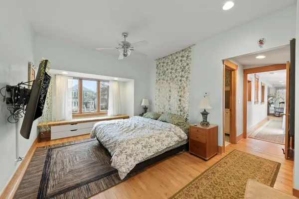 a spacious bedroom with a bed a mirror and a window