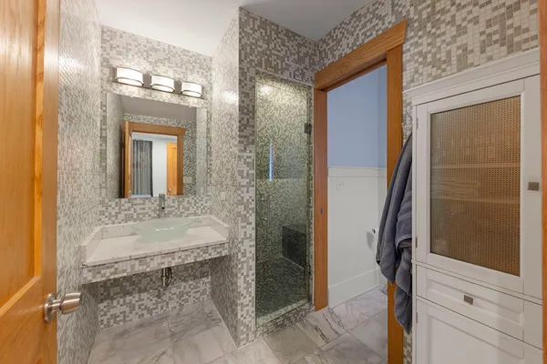 a bathroom with a granite countertop sink a mirror and a shower