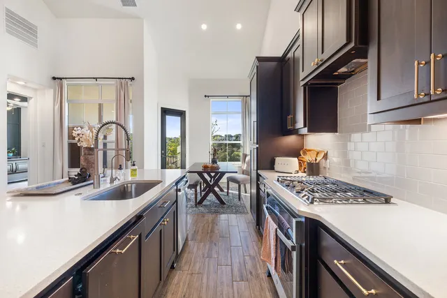 a kitchen with stainless steel appliances granite countertop a sink stove and cabinets
