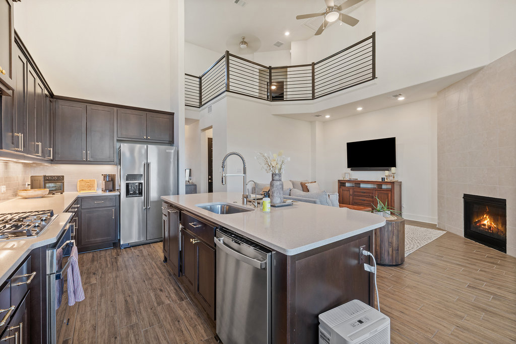 427 Cartwheel Bend, Unit 92 Austin, TX 78738 - Photo 15 of 40 a kitchen with stainless steel appliances a sink a stove a refrigerator cabinets and a dining table