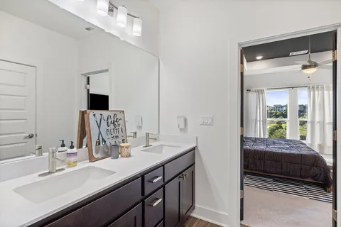 a en suite bathroom with a double vanity sink and a mirror