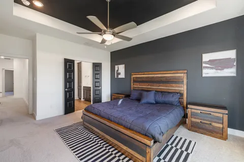 a bedroom with a large bed a chandelier and dresser