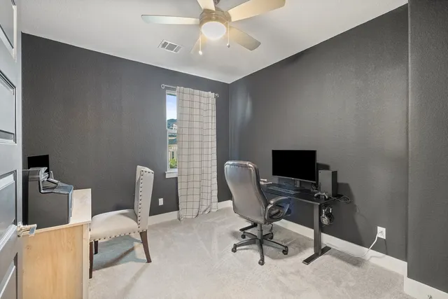 a view of a workspace with furniture and a window