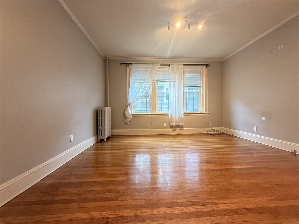 15 Colliston Road, Unit 5 Boston, MA 02135 - Photo 4 of 9 a view of empty room with wooden floor and fan