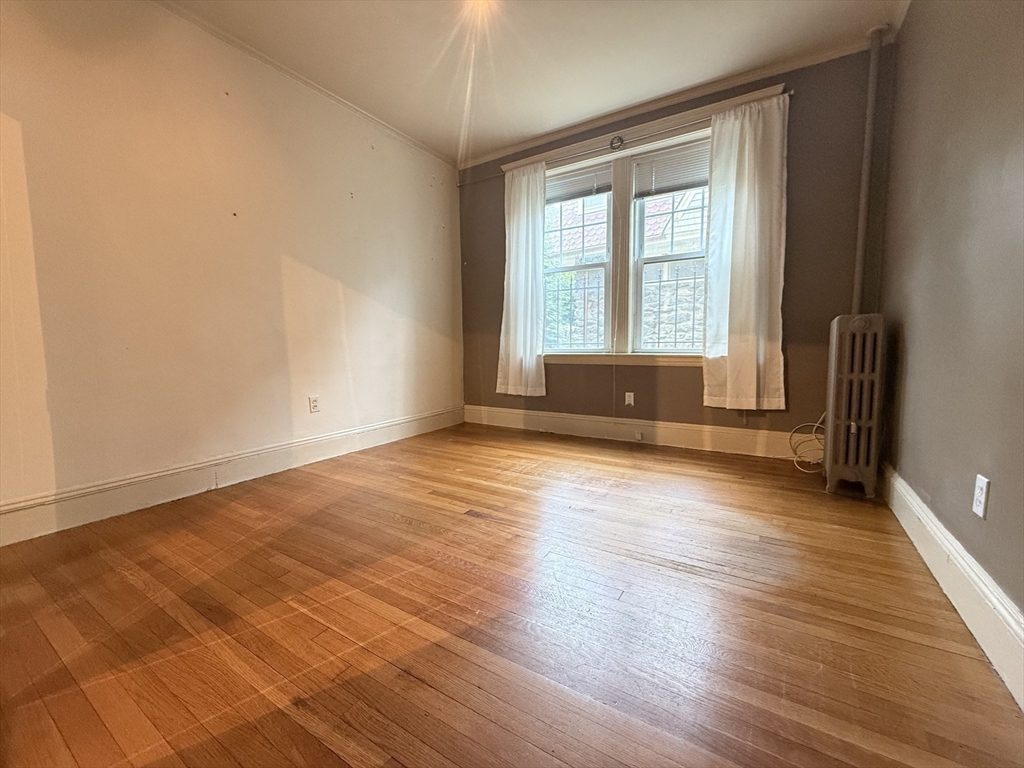 15 Colliston Road, Unit 5 Boston, MA 02135 - Photo 5 of 9 a view of empty room with wooden floor and fan