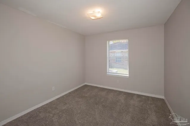an empty room with wooden floor and window