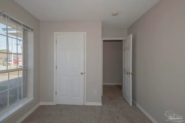 a view of an empty room with a chandelier fan