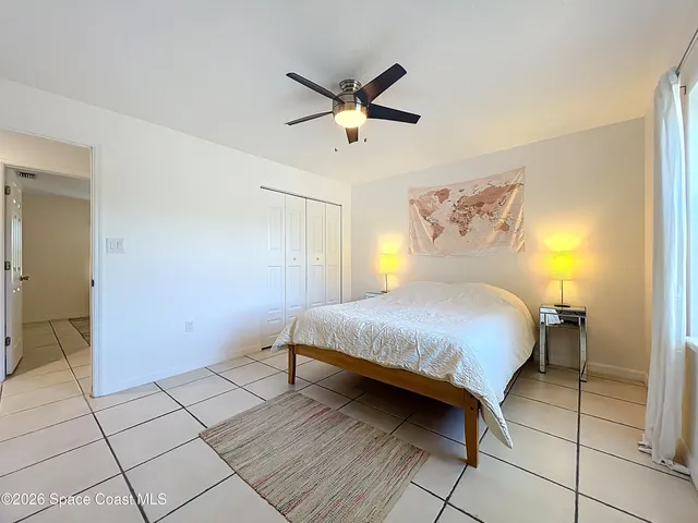 a view of a bedroom with a bed and wooden floor