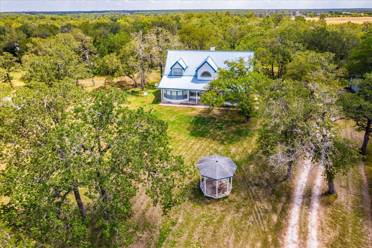 19106 Eyerley Road Manor, TX 78653 - Photo 35 of 40 A tranquil rural retreat, featuring a charming dwelling nestled amidst a verdant landscape with mature trees and a delightful gazebo.