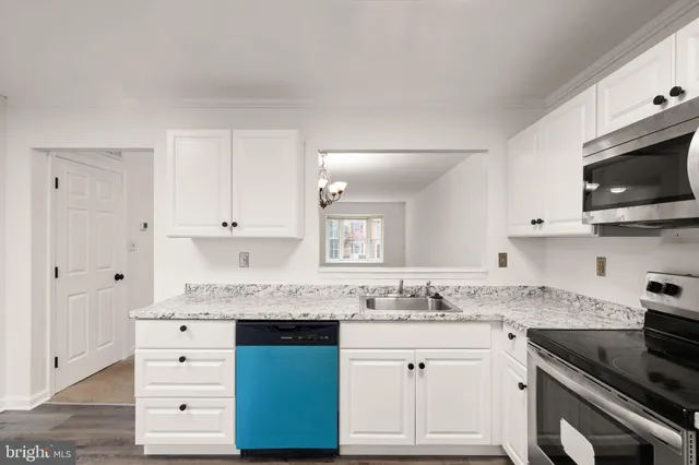 a kitchen with stainless steel appliances kitchen island granite countertop a refrigerator stove and sink