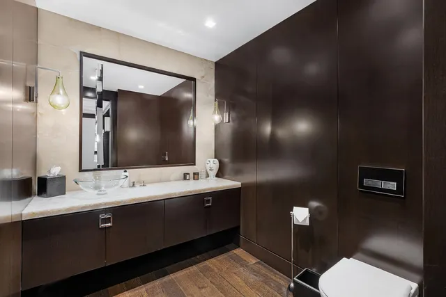 a bathroom with a toilet sink and mirror