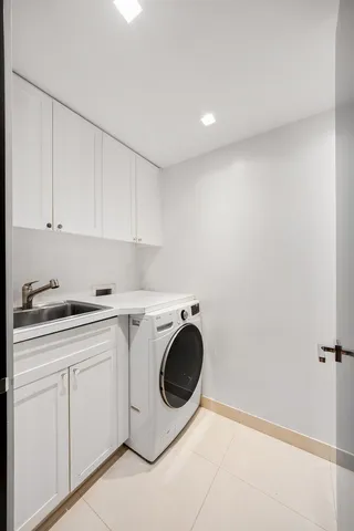a utility room with sink dryer and washer