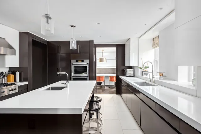 a large kitchen with a large counter top space appliances and cabinets