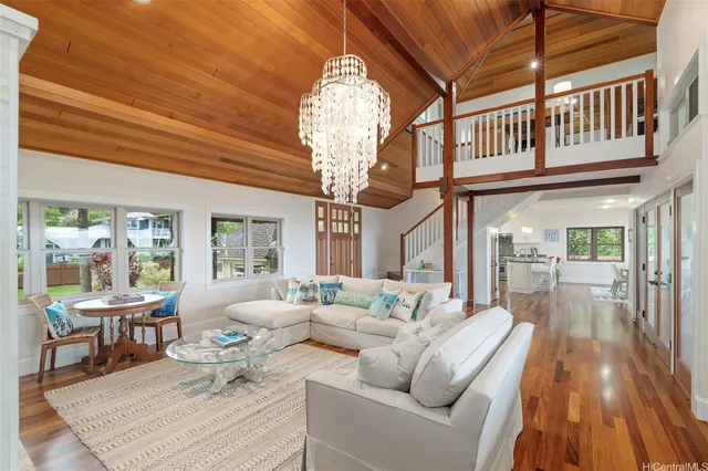 a living room with furniture a fireplace and a chandelier