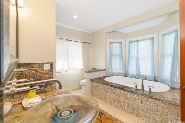a bathroom with a tub sink and mirror