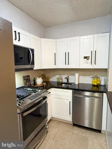 a kitchen with stainless steel appliances granite countertop a stove and a refrigerator