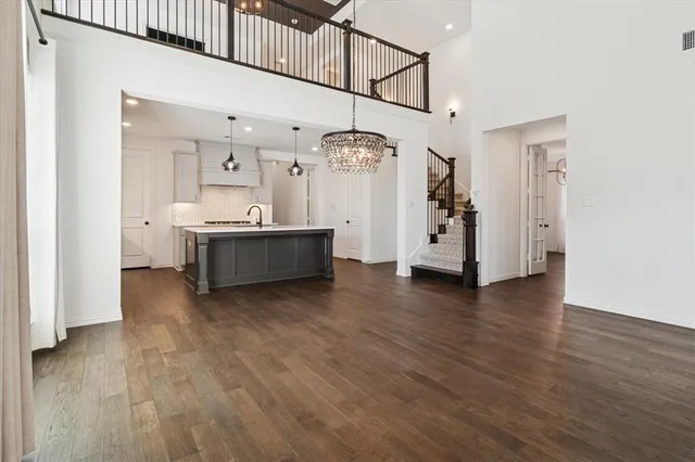 an empty room with wooden floor fireplace and windows