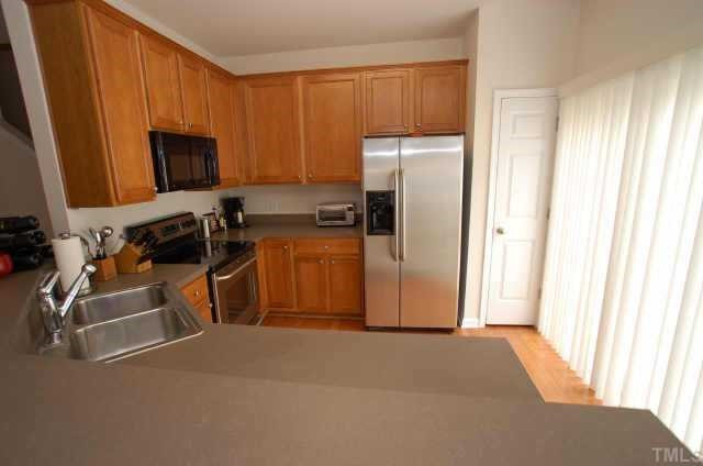 7038 Racine Way Raleigh, NC 27615 - Photo 4 of 12 Kitchen has 42' cabinets, stainless steel appliances and hardwood floors Other