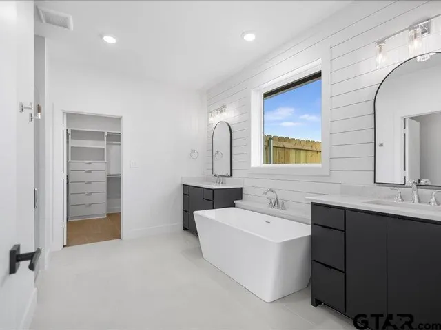 a en suite bathroom with a double vanity sink a mirror and a shower