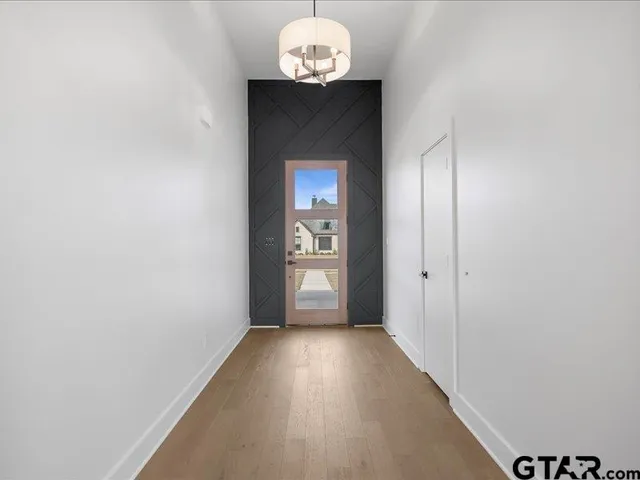 a view of a hallway with wooden floor